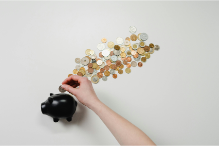 Woman putting coins into piggy bank